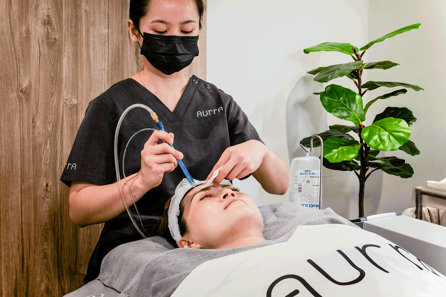 Image showing an Aurra therapist performing the Signature Jet Facial.